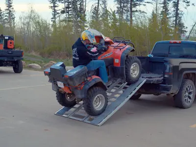 Photo of a person unloading their quad at an OHV staging area 